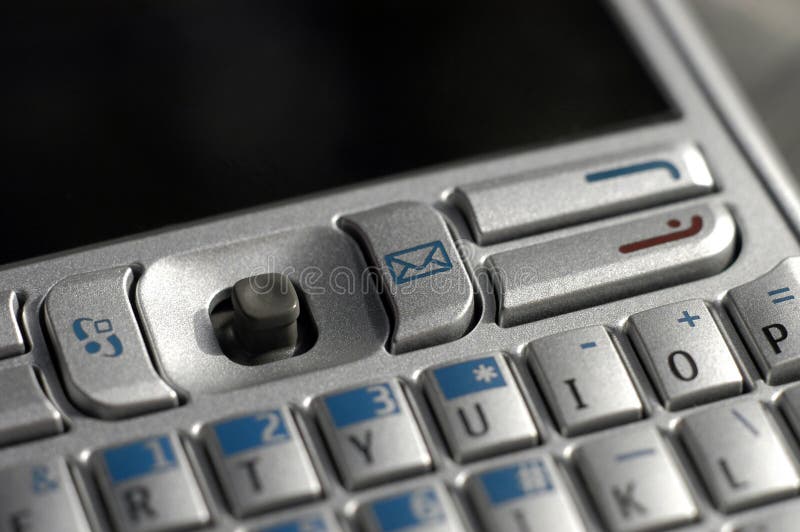 A detail view of the keys of a pocket email and phone gadget, dark area of screen provides space for copy. A detail view of the keys of a pocket email and phone gadget, dark area of screen provides space for copy