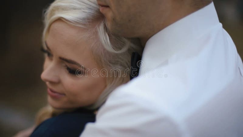 Close-up de pares novos bonitos no amor que abraça levemente no dia frio do outono