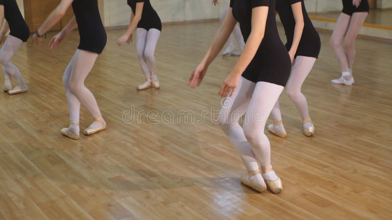 Close up de um grupo de moças e um professor da dança que aprende o bailado em um estúdio da dança