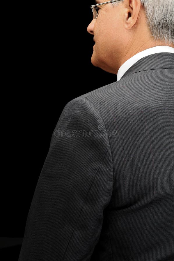 Close up de um homem de negócios maduro visto atrás dentro do perfil sobre um fundo preto imagem de stock royalty free Close up de um homem de negócios maduro visto atrás dentro do perfil sobre um fundo preto imagem de stock royalty free
