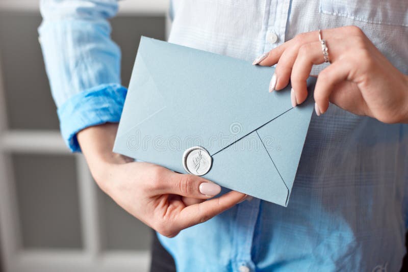 Close-up de uma moça que guarda um envelope retangular azul com convites, cartão do presente do produtos e serviços imagens de stock Close-up de uma moça que guarda um envelope retangular azul com convites, cartão do presente do produtos e serviços imagens de stock