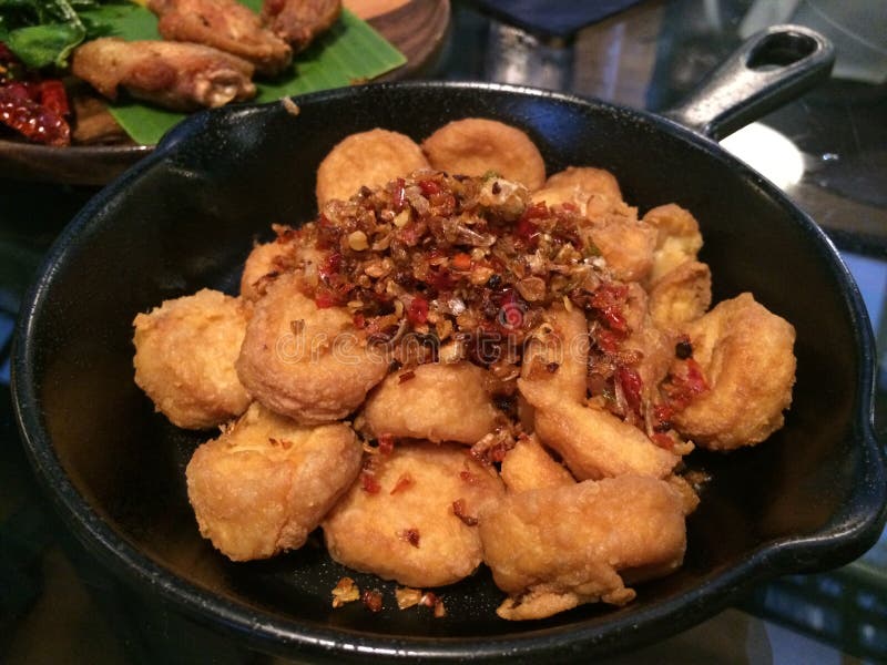 Close up deep fried and stir fried egg tofu chilli garlic and pepper on black dish, vegetarian menu mushroom, focus-on-foreground stock photography Close up deep fried and stir fried egg tofu chilli garlic and pepper on black dish, vegetarian menu mushroom, focus-on-foreground stock photography