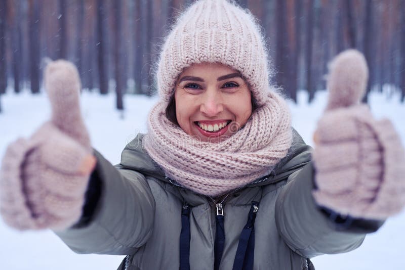 Close-up of delightful woman showing thumbs up to the camera