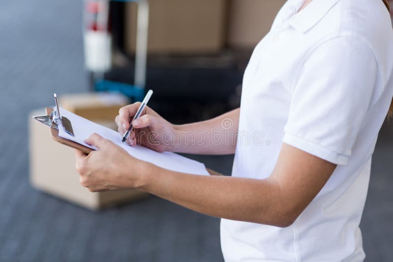 Close up of delivery woman is writing on a clipboard stock photo Close up of delivery woman is writing on a clipboard stock photo