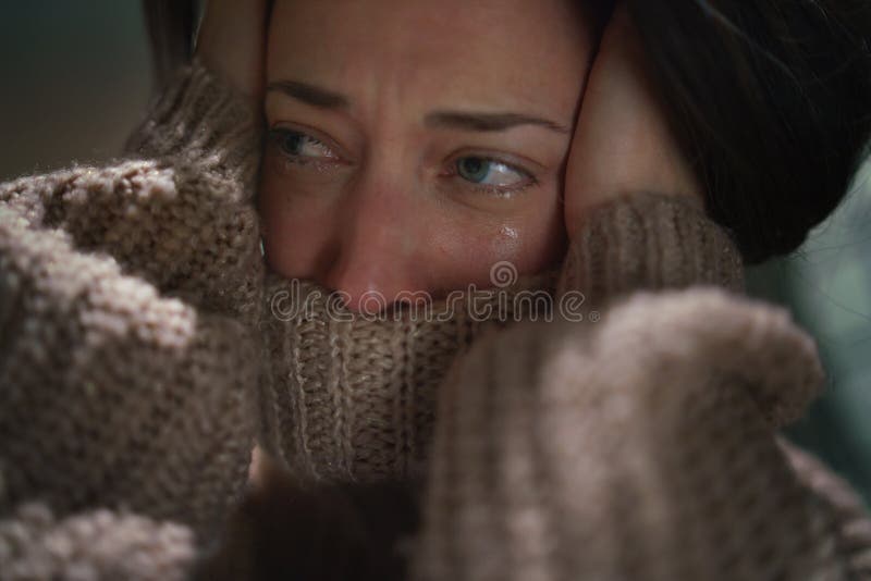 Close-up of depressed mid-adult lonely woman crying in the dark.