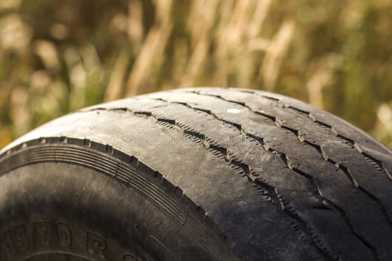 Close-up detail of car wheel tire badly worn and bald because of poor tracking or alignment of the wheels.