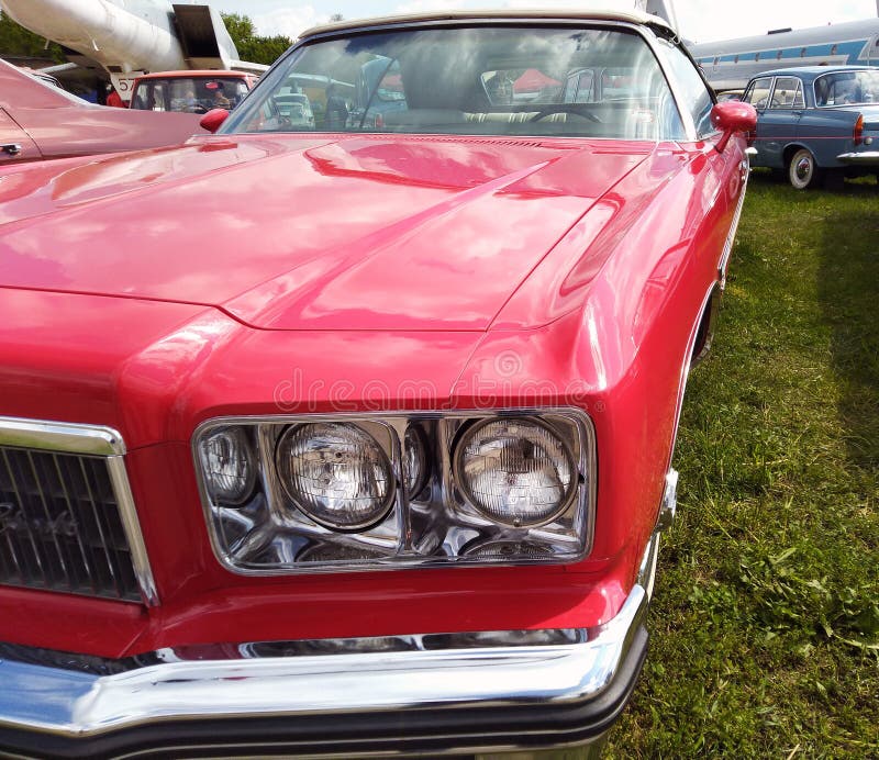 Close up, headlights of a shiny red classic car with focus on headlights and hood stock photos Close up, headlights of a shiny red classic car with focus on headlights and hood stock photos