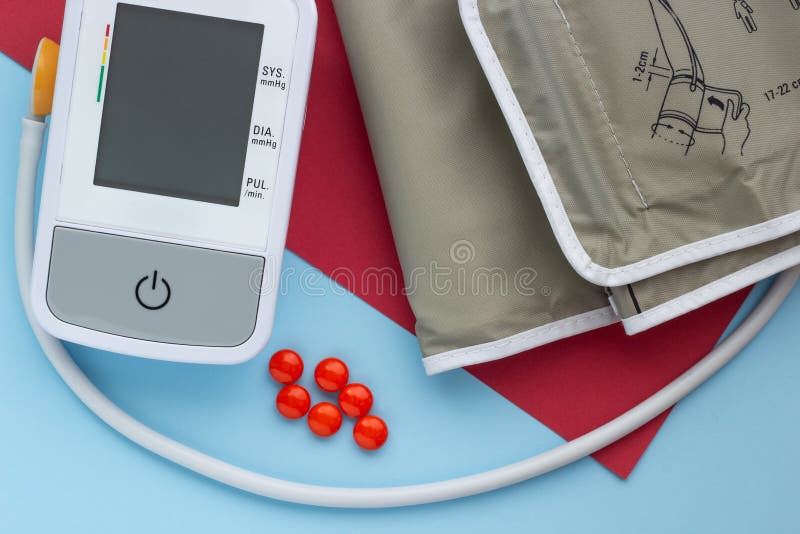 Close-up, a device for measuring blood pressure with tablets on a blue and red background stock photos Close-up, a device for measuring blood pressure with tablets on a blue and red background stock photos