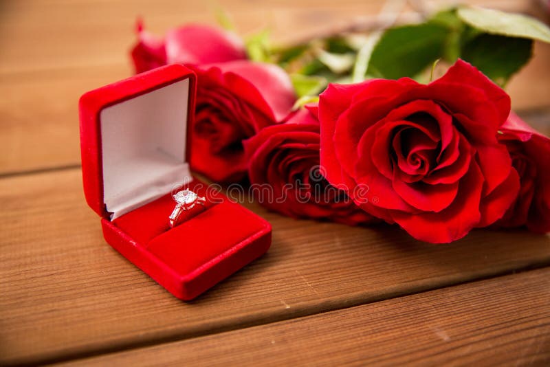 Close Up Of Diamond Engagement Ring And Red Roses Stock 