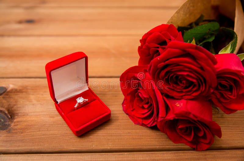 Close Up Of Diamond Engagement Ring And Red Roses Stock ...