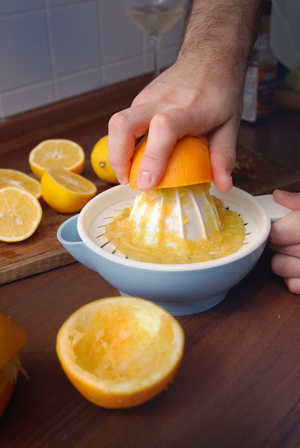 Close-up die van de mens die citrusvruchtenpers met behulp van, jus d'orange voorbereidt Verticale vorm, bebouwde mening stock fotografie Close-up die van de mens die citrusvruchtenpers met behulp van, jus d'orange voorbereidt Verticale vorm, bebouwde mening stock fotografie