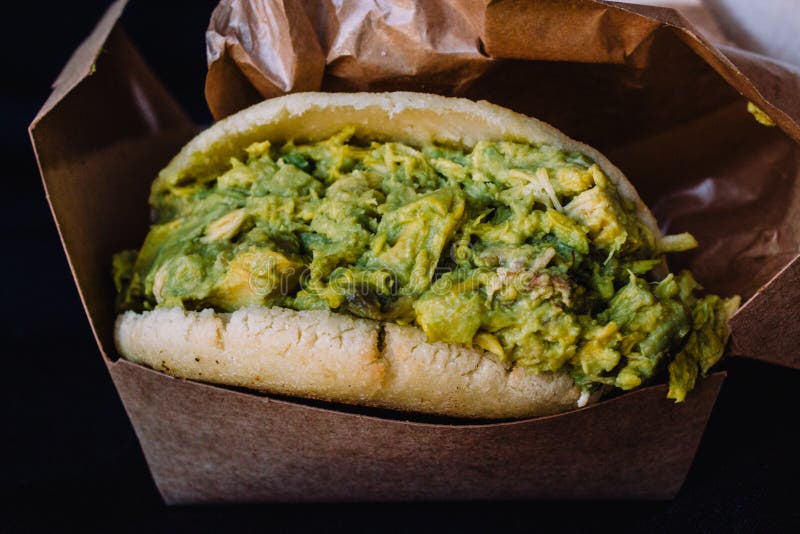 Reina pepiada on a black background. Is a traditional dish from Venezuela, made with an arepa filled with avocado and meat. royalty free stock photography Reina pepiada on a black background. Is a traditional dish from Venezuela, made with an arepa filled with avocado and meat. royalty free stock photography