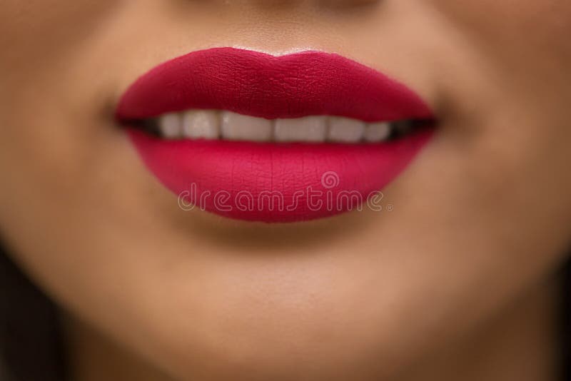 Close-up do modelo asiático moreno do sorriso bonito com batom vermelho em seus bordos foto de stock royalty free Close-up do modelo asiático moreno do sorriso bonito com batom vermelho em seus bordos foto de stock royalty free