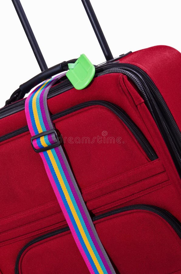 Closeup of bright green luggage tag and colorful belt on red suitcase. Closeup of bright green luggage tag and colorful belt on red suitcase