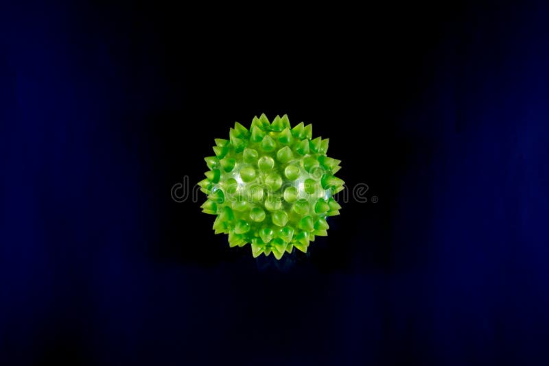 Green colored sphere shaped virus with many protein spikes on blue background. Green colored sphere shaped virus with many protein spikes on blue background