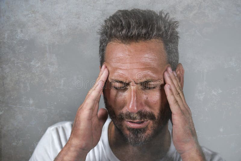 Close up dramatic portrait of young attractive anxious and depressed man in pain with hands on his head suffering headache and royalty free stock image Close up dramatic portrait of young attractive anxious and depressed man in pain with hands on his head suffering headache and royalty free stock image