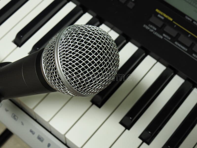 Close-up of a dynamic vocal microphone and a digital keyboard. royalty free stock photos Close-up of a dynamic vocal microphone and a digital keyboard. royalty free stock photos