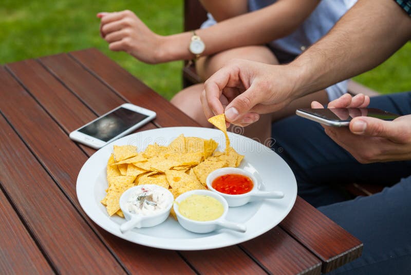 The close-up of eating tortilla-chips, there is telephone either