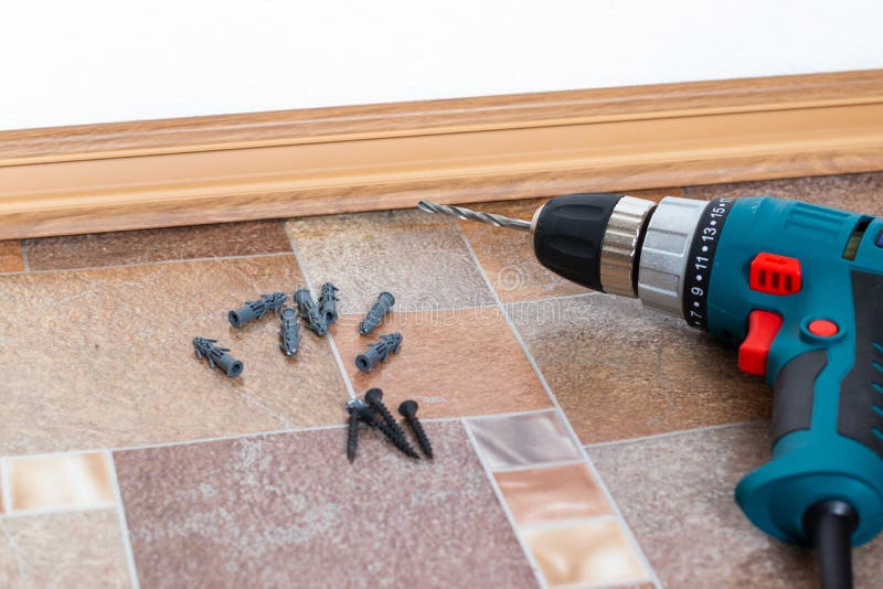 Furniture assembly parts and tools for self assembly furniture, on the floor.Installation of plastic floor plinth. Interior detail