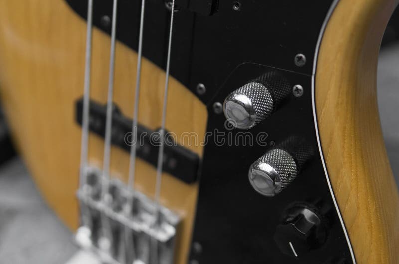Close up of electrical bass guitar fingerboard. Wooden bass with volume controller. stock photo Close up of electrical bass guitar fingerboard. Wooden bass with volume controller. stock photo