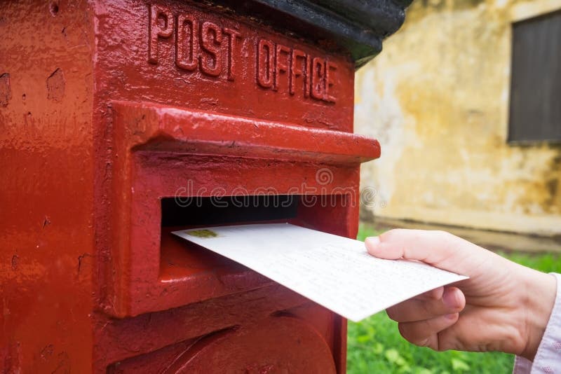 Close up em uma mão masculina que põe uma letra em uma caixa de letra vermelha Conceito do tipo do vintage de uma comunicação