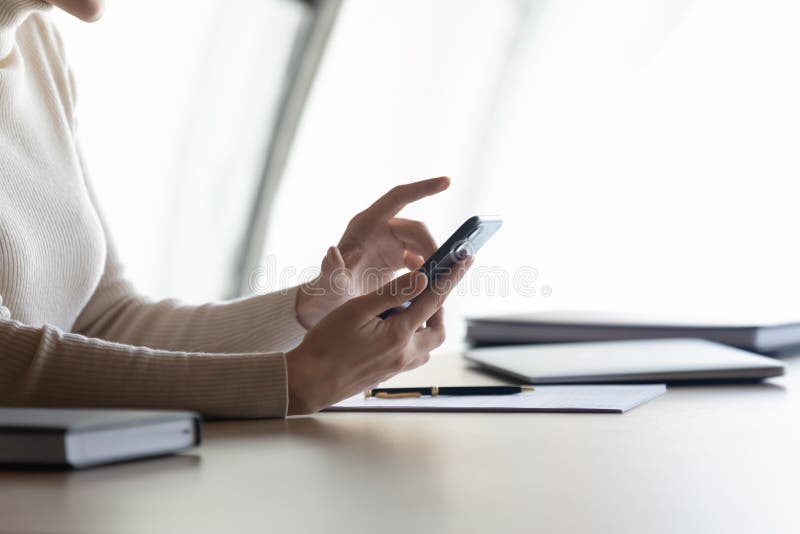 Businesswoman holding cellphone e-mailing to client solve issues distantly