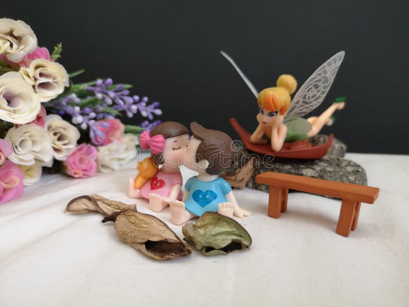 Close-up en macro die van miniatuur kussende babys in de tuin wordt geschoten terwijl fee Tinkerbell die erachter besluipen stock afbeeldingen Close-up en macro die van miniatuur kussende babys in de tuin wordt geschoten terwijl fee Tinkerbell die erachter besluipen stock afbeeldingen