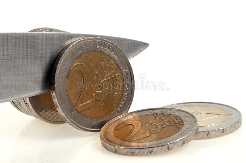 Tax concept with a roll of two euro coins cut with a knife close-up on a white background