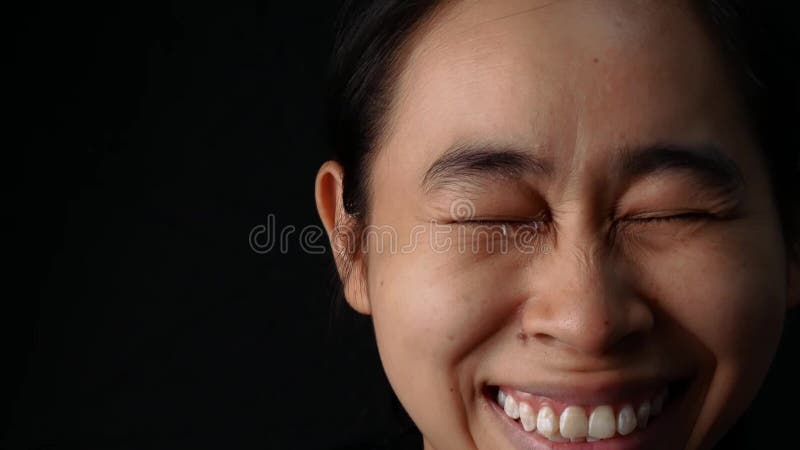 Close up eyes of woman crying with smile on black background