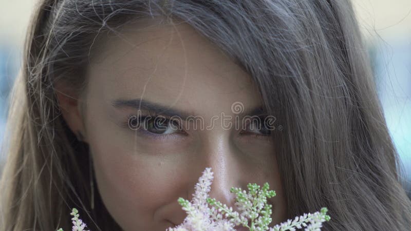 Portrait of beautiful girl smells flowers