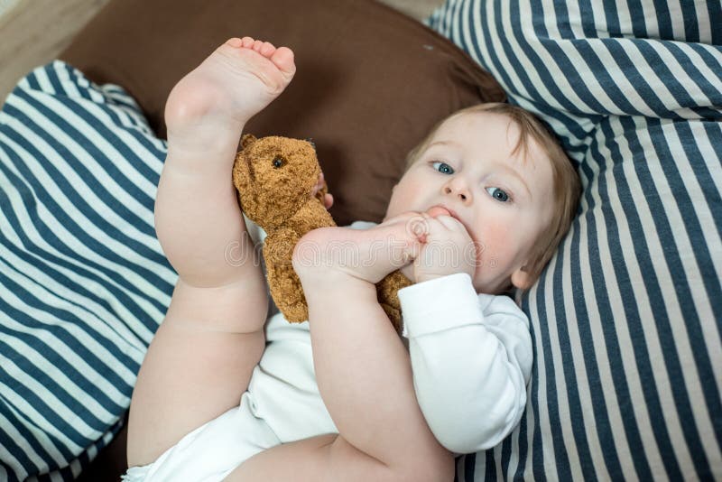 Close Up Face Of Kid Yawning And Holding Teddy Bear, Sleepy Child Yawning And Looking At Cameta