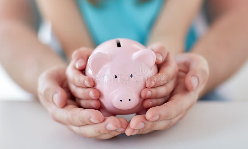 Familia,, dinero, inversiones a vista de cerca de a manos posesión rosa pequeno cerdo Banco.