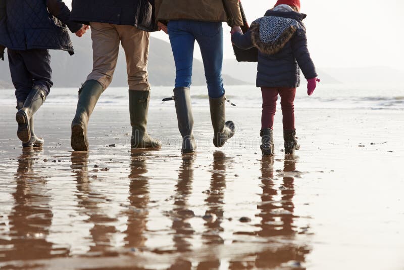 Close Up Of Family Walking Along Winter Beach stock photo Close Up Of Family Walking Along Winter Beach stock photo