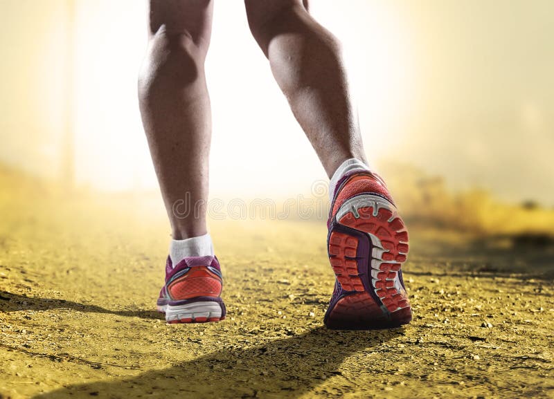 Close up feet with running shoes and female strong athletic legs of sport woman jogging in fitness training workout on off road trail track design in advertising poster style sunset extreme