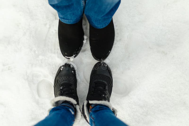 Close-up feet of a young couple in warm winter shoes standing on the snow. The legs of a man and a woman in winter boots stand on royalty free stock photo Close-up feet of a young couple in warm winter shoes standing on the snow. The legs of a man and a woman in winter boots stand on royalty free stock photo