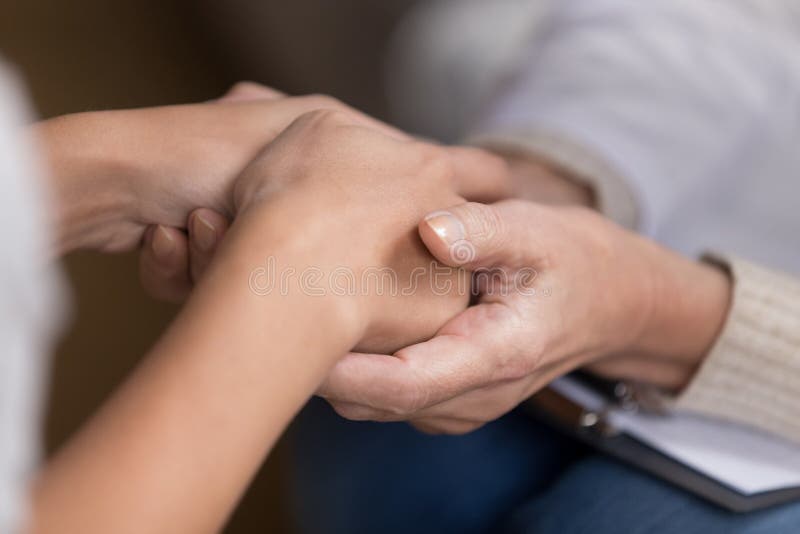 Close up of female doctor hold patient hands showing support