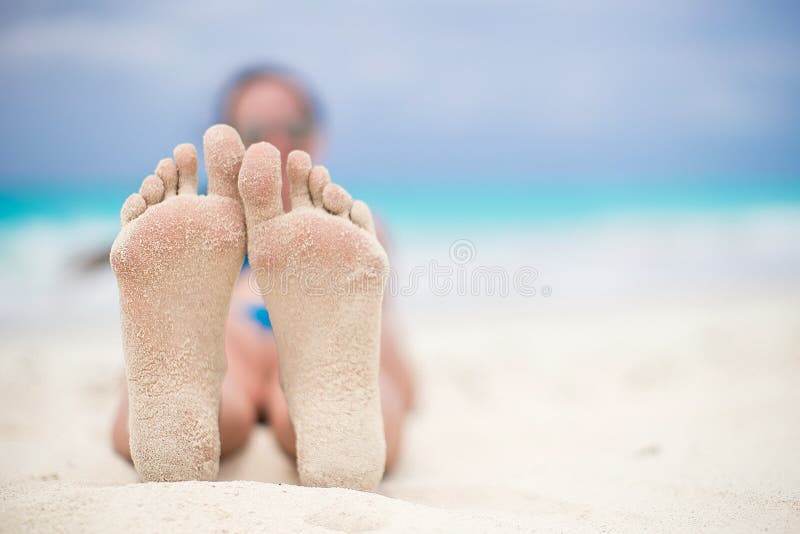 Close up of female feet on white sandy beach stock photography