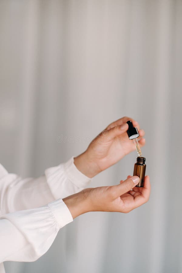 Close-up of female hands holding a bottle of essential oil, Aromatherapy stock images
