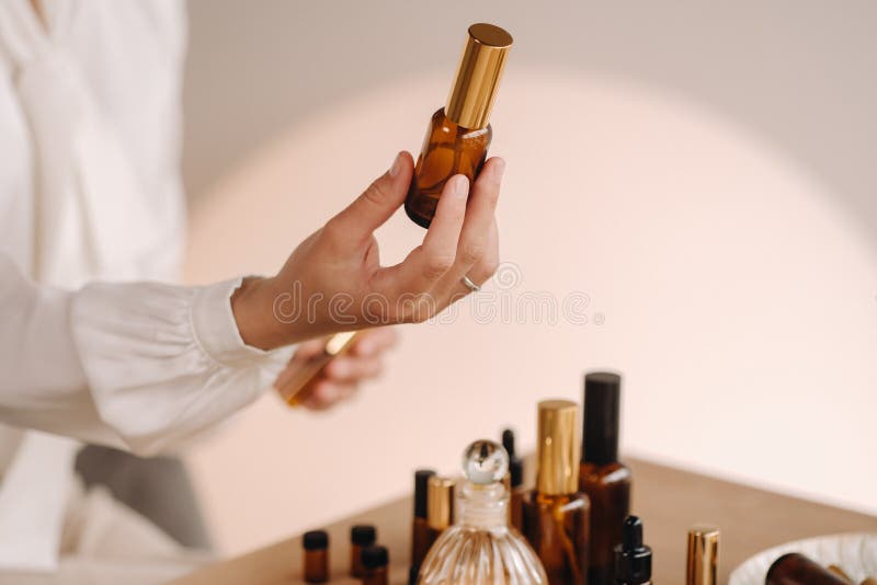 Close-up of female hands holding a bottle of essential oil, Aromatherapy stock photo