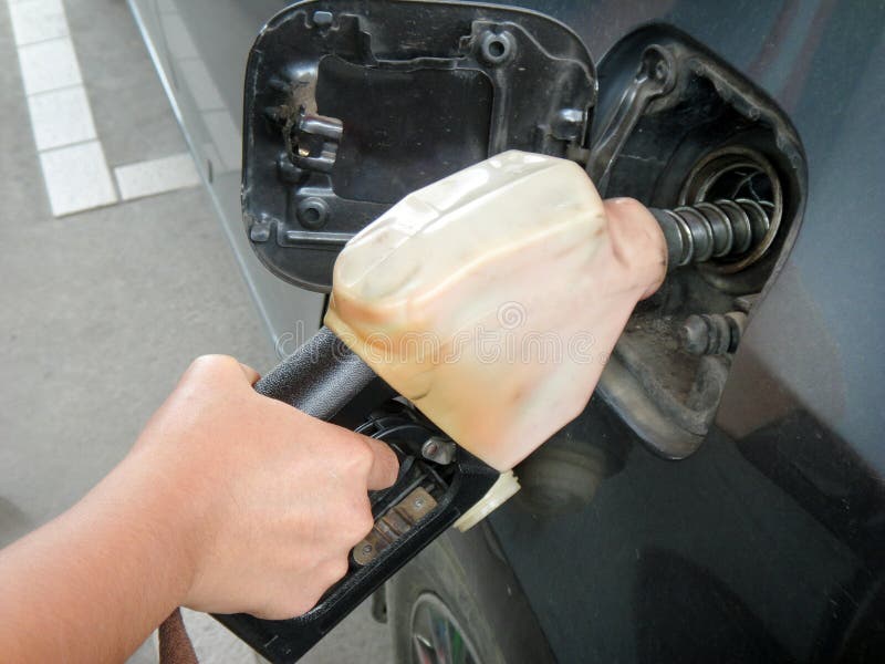 Close up female`s hand pumping fuel by dispenser in cars at gas station.Transportation concept .