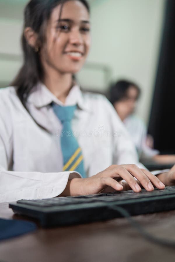 Close up of female students& x27; hands typing on the keyboard while using the computer with the background of high school royalty free stock images