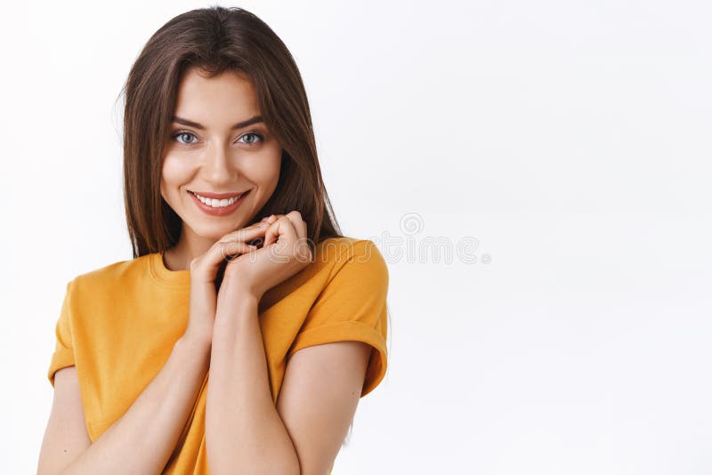 Close-up feminine flirty and romantic young girlfriend in yellow t-shirt, making silly tender expression, clasp hands