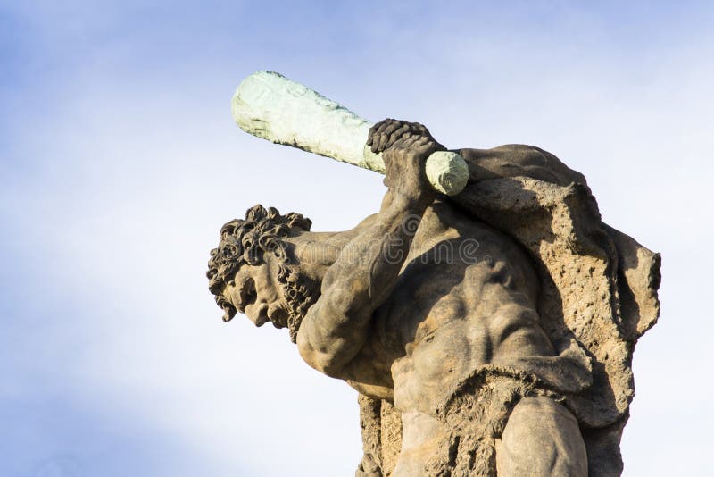 Close-up of the fighter statue holding club looking down with blue sky in background