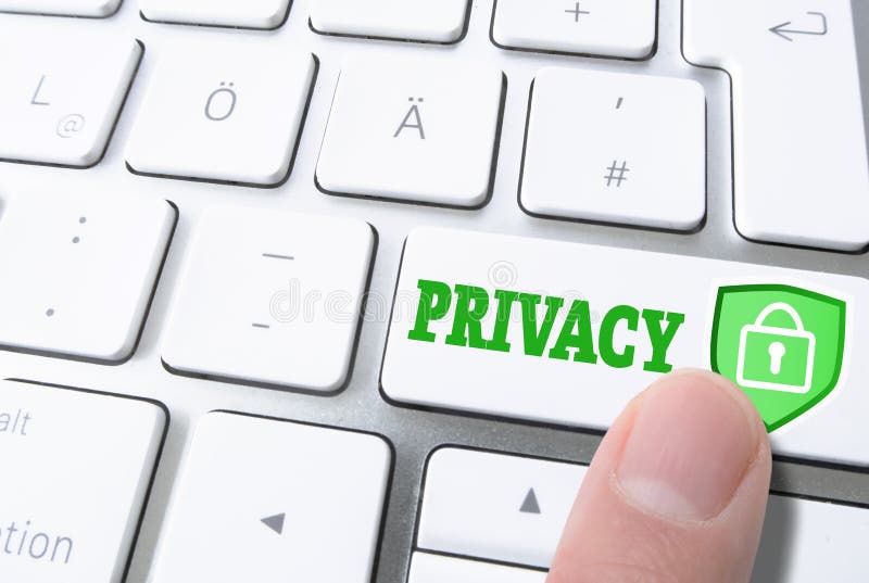 Finger pressing key labeled PRIVACY on computer keyboard stock image