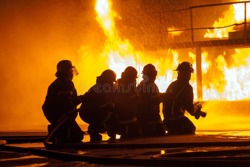 Close up of firefighters spraying burning structure during a firefighting exercise royalty free stock photos