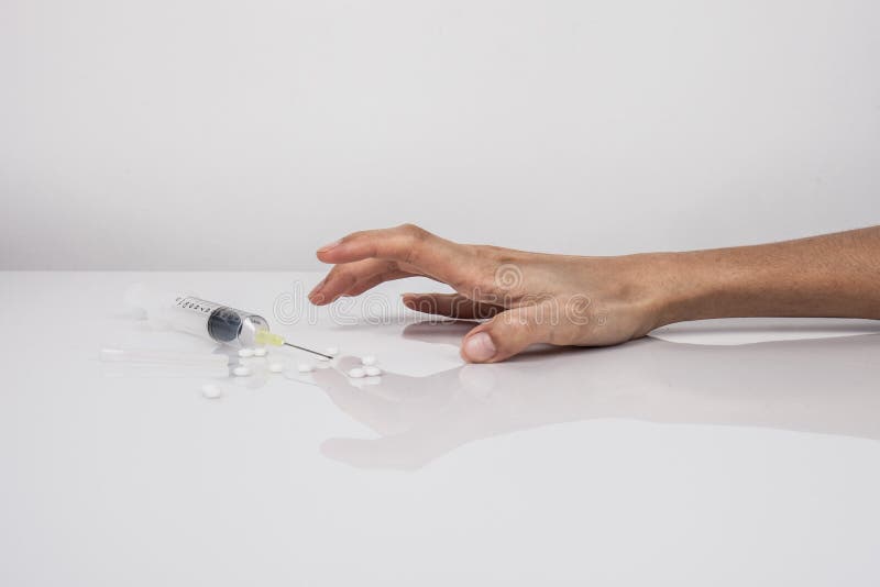 Close-up on the floor of the syringe with the drug. In the background, a young drug addict