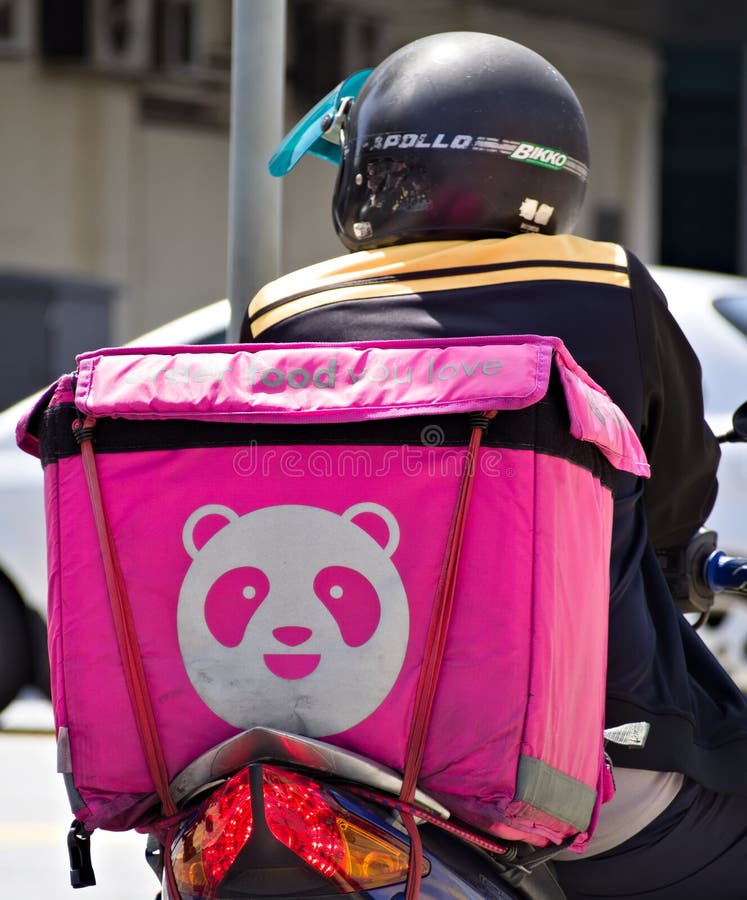 FoodPanda logo on a FoodPanda container at the back of a motorbike. The FoodPanda delivery rider is stopping at the traffic light of a busy road junction in Ipoh, Malaysia at mid-day. FoodPanda logo on a FoodPanda container at the back of a motorbike. The FoodPanda delivery rider is stopping at the traffic light of a busy road junction in Ipoh, Malaysia at mid-day