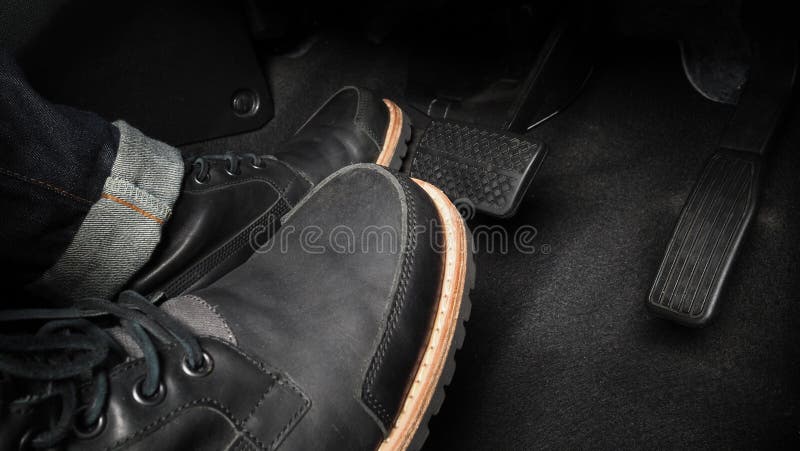 Close up the foot pressing foot pedal of a car to drive. Accelerator and brake