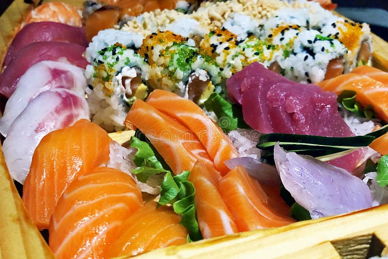 Close-up of full fresh sushi boat with salmon and raw fish unagi sake