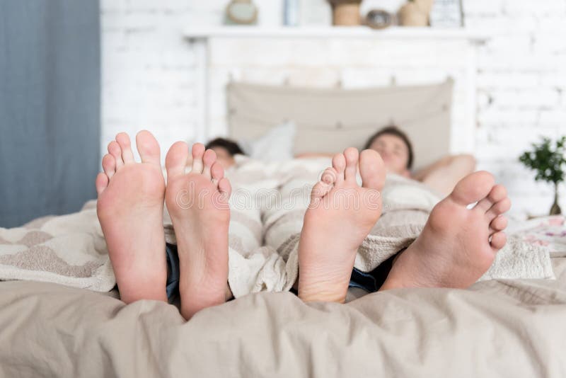 Close up of gay couples feet lying in bed stock image Close up of gay couples feet lying in bed stock image